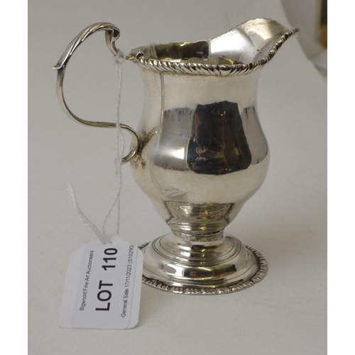 110 - A George II silver helmet form milk jug, with gadrooned rim c scroll handle, raised on circular plat... 