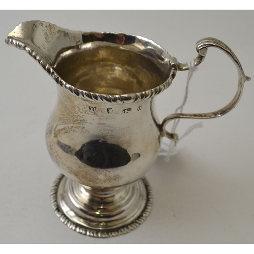 110 - A George II silver helmet form milk jug, with gadrooned rim c scroll handle, raised on circular plat... 