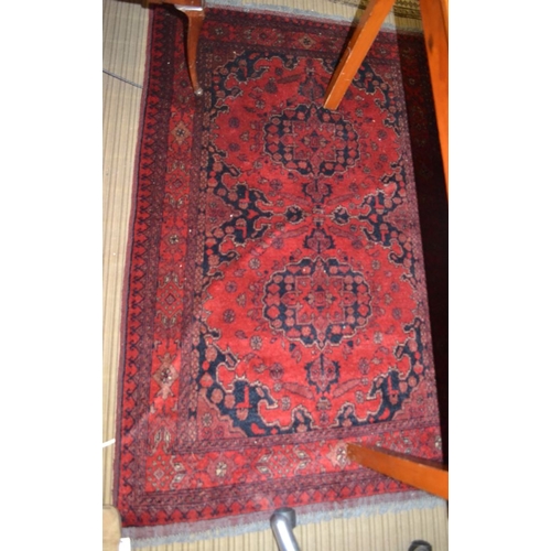 86 - A Persian rug, with stylized motifs on a red field, bordered & fringed, 160cm x 103cm