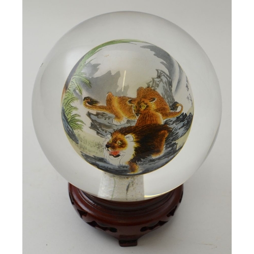 103 - A Chinese internally painted glass ball, decorated with a pride of lions, approx 11cm diameter, rais... 