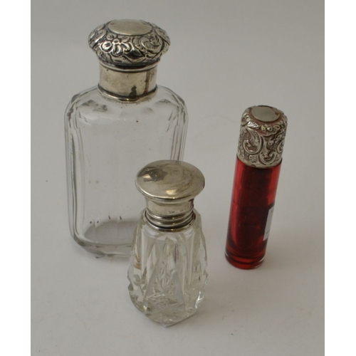 21 - A Victorian ruby glass scent bottle with silver top, together with two other glass scent bottles wit... 