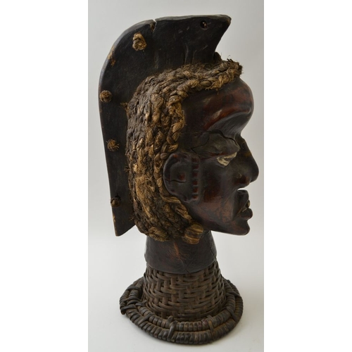 74 - An African sculptural head, mixed media, including leather and straw raised upon a plaited cane neck... 