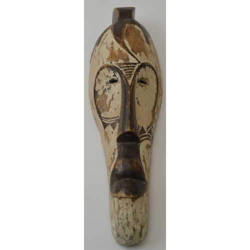 77 - A carved wood African mask, elongated form, remains of partial painting, 32cm