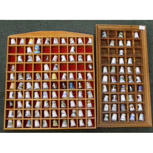 142 - A collection of thimbles housed in two wall mounting display cases