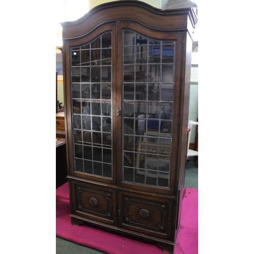 234 - Oak bookcase with leaded glass doors over carved front two door cupboard