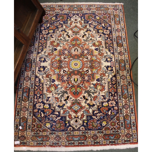 215 - A Persian design wool rug, decorative design on a cream ground, fringed and bordered 109cm x 153cm