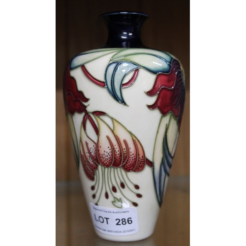 286 - A Moorcroft pottery vase, tube lined and painted floral decoration on a cream ground, impressed and ... 