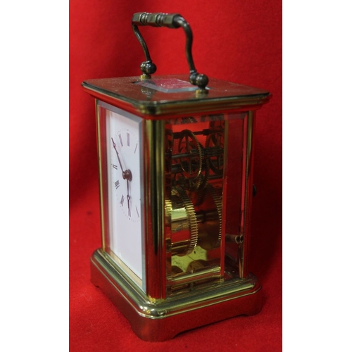 293 - A brass frame carriage clock, white enamel dial with Roman numerals, having key