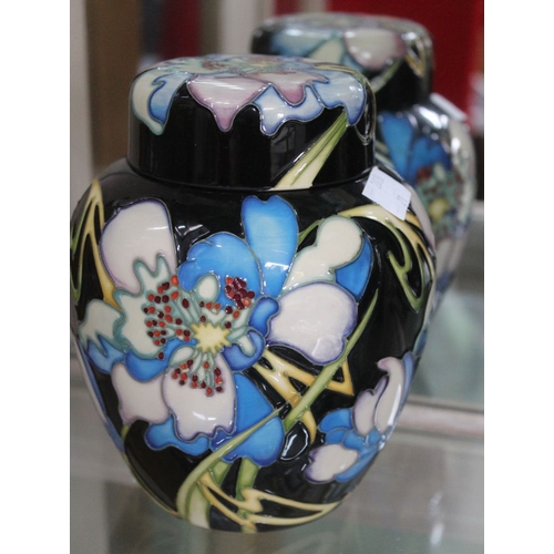 302 - A Moorcroft pottery ginger jar, tube lined and painted floral decoration on a noir ground, impressed... 