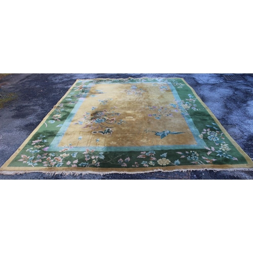 366 - A roomsize Chinese carpet, golden ground with vase of flowers decoration. Green floral border 460cm ... 