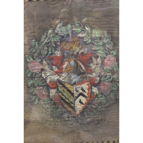 87 - A silk woven panel depicting a coat of arms in a double sided glazed oak frame