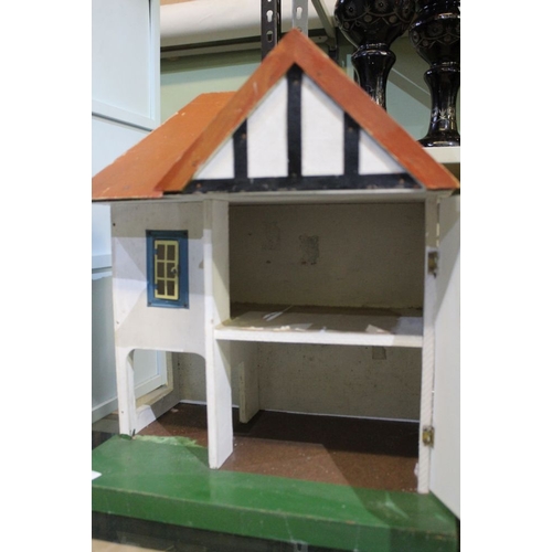 240 - A small wooden dolls house in the form of a 1930's style town house. 42 cm in height on a solid gree... 