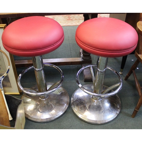 279 - A pair of red leather topped chrome base bar stools