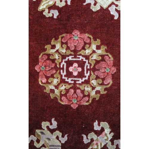 323 - A pair of Chinese carved rugs, deep red ground with stylised motifs, bordered and fringed, 62cm x 12... 