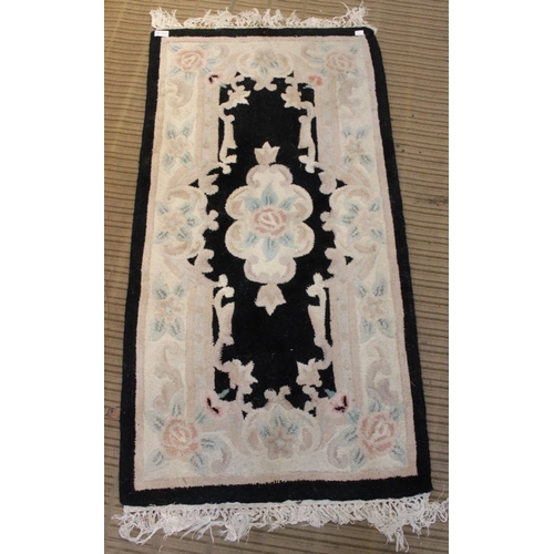 185 - Three Oriental inspired dark ground floor rugs