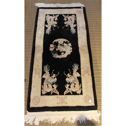 185 - Three Oriental inspired dark ground floor rugs