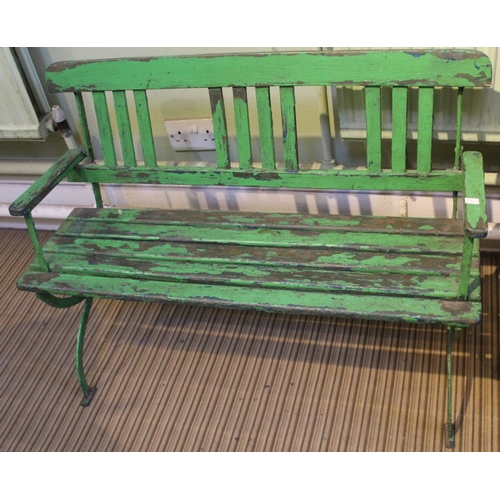 9 - An Edwardian child's garden bench, wrought iron and wooden lathe of open arm design, green painted, ... 