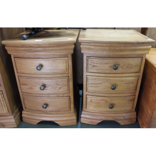 141 - A pair of modern light oak bow fronted three drawer chests