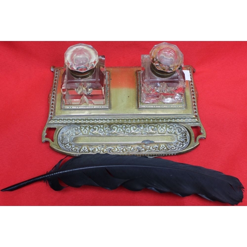 142 - A late Victorian brass standish, with two glass inkwells and pen tray, complete with a black quill