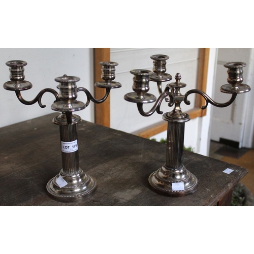 176 - A pair of silver plate three sconce candelabra with a pair of brass candle sticks