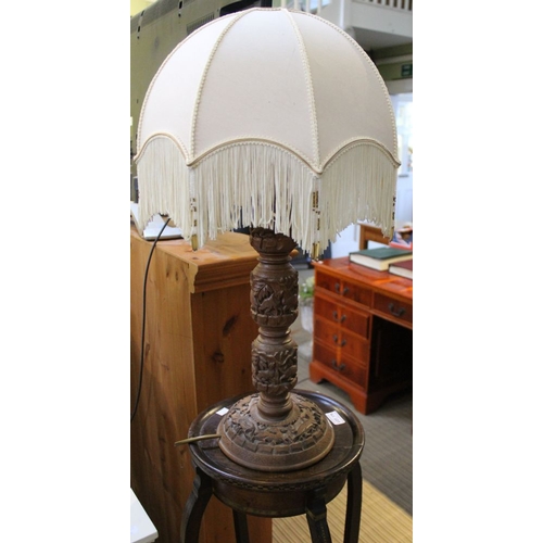 179 - A carved wood Eastern table lamp with cream shade, raised upon an Edwardian Jardiniere stand