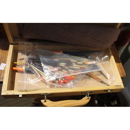 185 - A vintage wooden tackle box containing a selection of vintage floats and quills