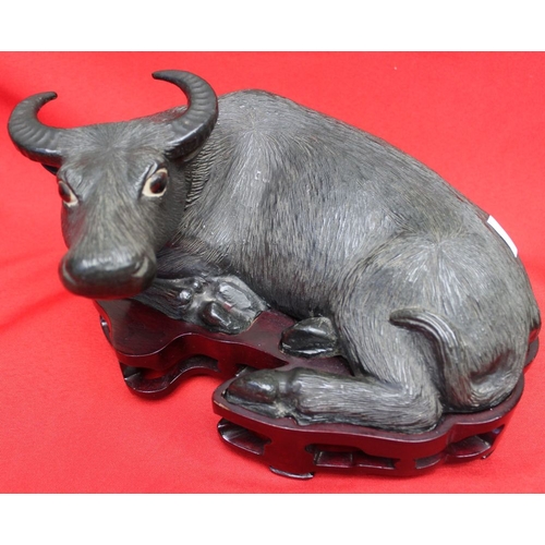 259 - A pair of Chinese glazed ceramic Water Buffalo in reclining position, raised on carved wood bases 17... 