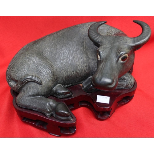 259 - A pair of Chinese glazed ceramic Water Buffalo in reclining position, raised on carved wood bases 17... 