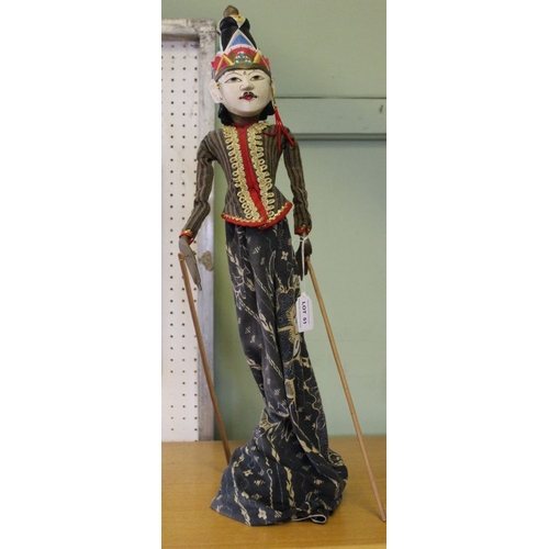 51 - A carved and painted wood Indonesian puppet, fabric dressed, with stand base 57cm high