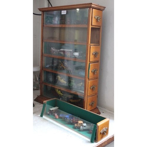 62 - An early 20th century purpose built six drawer glazed front display cabinet, containing a good selec... 