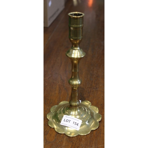 154 - An 18th century brass candlestick with petal shaped base 21cm high