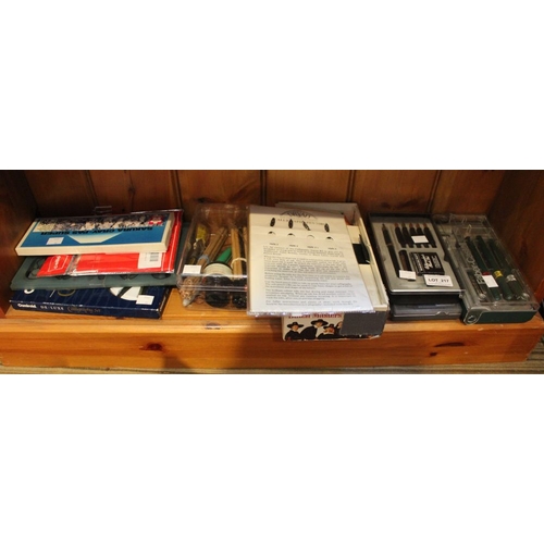 217 - A shelf containing a selection of calligraphy pens accessories etc