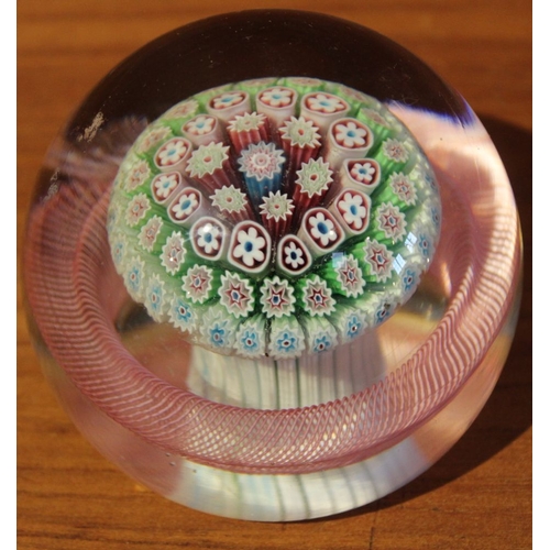 233 - A 19th century paperweight enclosing a Millefiori mushroom basket, surrounded with a twisted pink ba... 