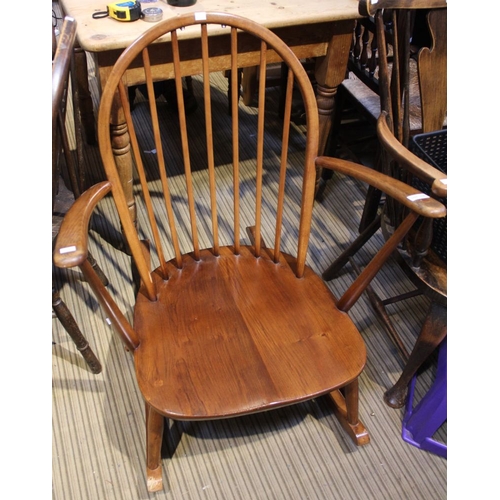 239 - An Ercol bow spindle back rocking chair with splayed arms