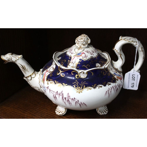 179 - A 19th century china teapot, gilded blue with fancy bird decoration, raised on scallop feet