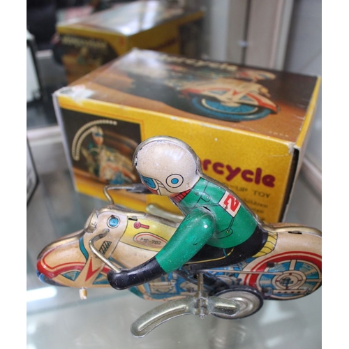 185 - Three tin plate toys, includes a clockwork Zeppelin, a clockwork motorcycle and a model of a 1924 He... 