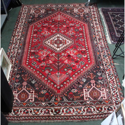 277 - A large Afgan floor rug, geometric pattern on red ground, 270cm x 150cm