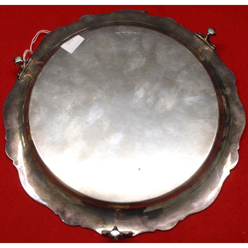 5 - A silver salver of Georgian design, wavy edge, raised on three cast claw feet, Birmingham 1925, 25cm... 