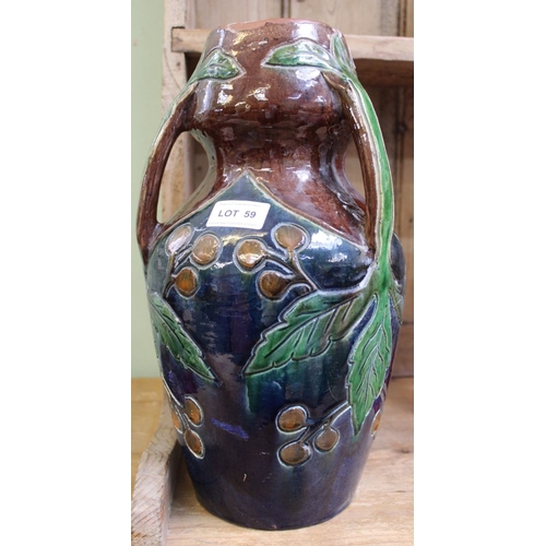 59 - A glazed pottery vase in the manner of Christopher Dresser, having three sprig handles, incised frui... 