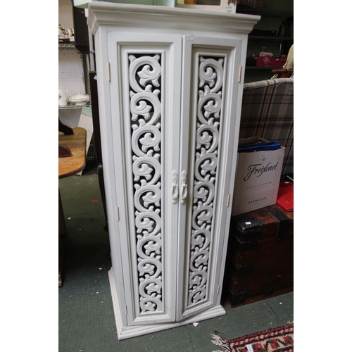 15 - An ornately carved twin doors, wine storage cupboard