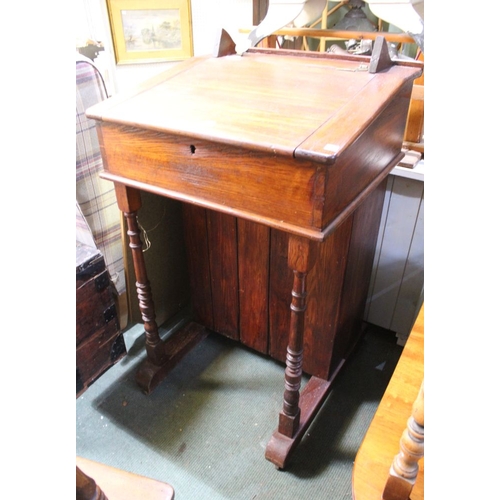 7 - A 19th century oak clerks desk with lift up lid and twin ink wells