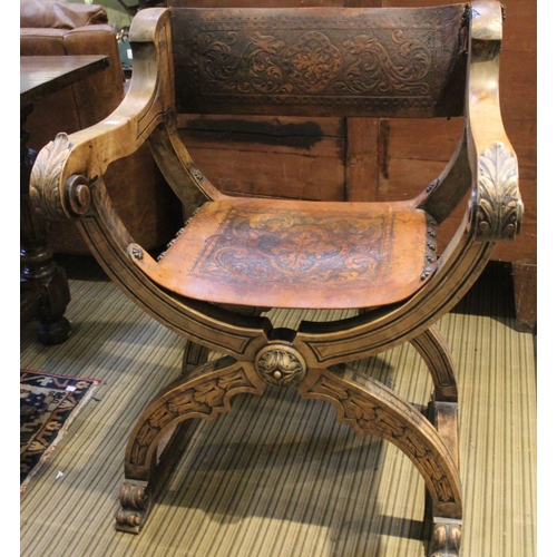 132 - An Italian folding X-shaped chair, acanthus scroll terminal open arms, tooled leather seat and back