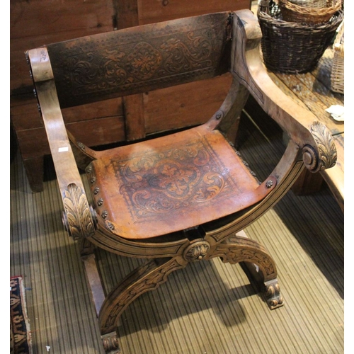 132 - An Italian folding X-shaped chair, acanthus scroll terminal open arms, tooled leather seat and back