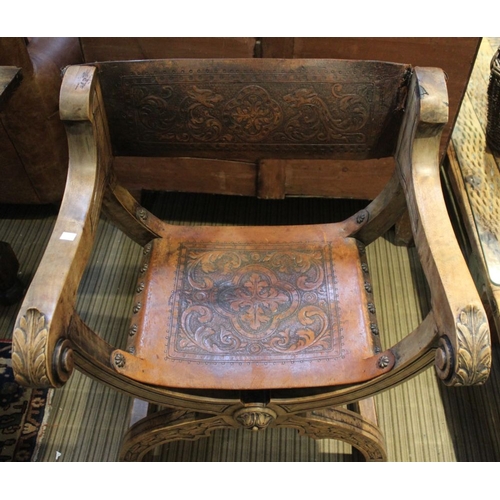 132 - An Italian folding X-shaped chair, acanthus scroll terminal open arms, tooled leather seat and back