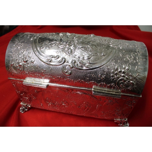 17 - An Edwardian silver table casket, having hinged domed lid, raised on cast feet, repousse decoration ... 