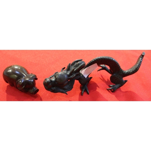 22 - A cast bronze Chinese Dragon, together with a carved hardwood pig netsuke & a carved wood flute (3)