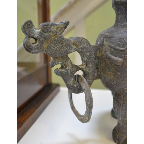 257 - A Chinese cast metal censer of Archaic form, dragon decoration, raised on three legs 43cm high