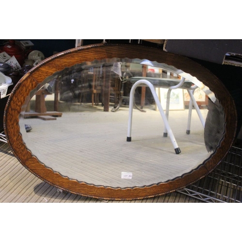 77 - An Edwardian oval bevel edged wall mirror with mahogany frame, satinwood & ebony cross-banding, toge... 