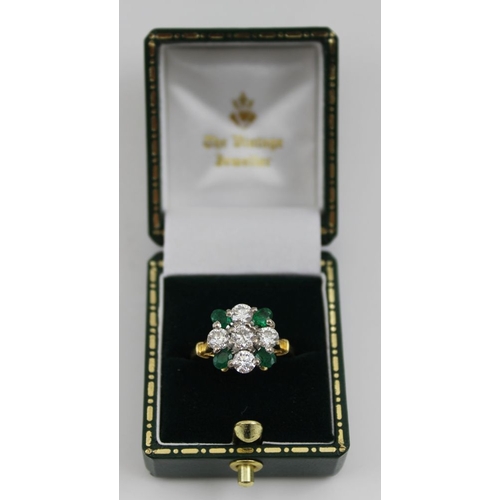 10 - A diamond and emerald ring, set five brilliant cut diamonds in a cross form, having four oval cut em... 