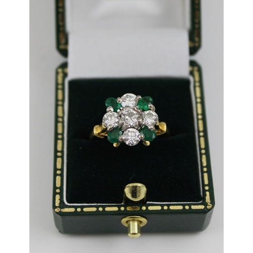 10 - A diamond and emerald ring, set five brilliant cut diamonds in a cross form, having four oval cut em... 